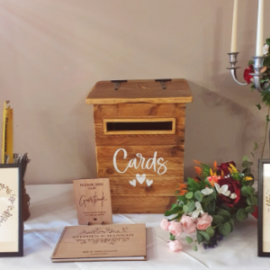 wooden card box on a table with a guest book at a wedding