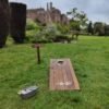 Cornhole rustic wedding game on a lawn with a castle in the background